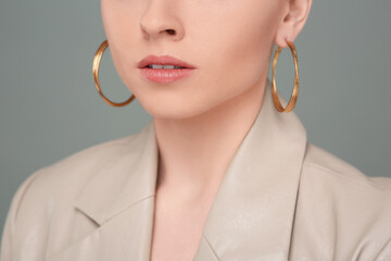 Wall Mural - Woman with elegant earrings on gray background, closeup