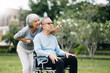 Asian senior couple having a good time. They laughing and smiling while sitting outdoor at the park. Lovely senior couple.