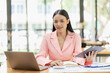 © ArLawKa - Asian businesswoman using laptop computer with documents The notebook is on the table. Report analysis planning Financial statistics