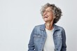Portrait of a confident Israeli woman in her 50s wearing a denim jacket against a white background