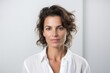 © Leon Waltz - medium shot portrait of a serious, Israeli woman in her 40s wearing a chic cardigan against a white background