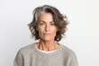 © Leon Waltz - medium shot portrait of a serious, Israeli woman in her 40s wearing a cozy sweater against a white background