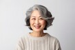 © Leon Waltz - medium shot portrait of a Japanese woman in her 50s wearing a cozy sweater against a white background