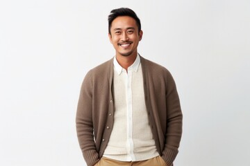 Canvas Print - medium shot portrait of a happy Filipino man in his 30s wearing a chic cardigan against a white background