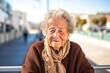 © Leon Waltz - portrait of a happy 100-year-old elderly Israeli woman wearing a cozy sweater against a modern architectural background