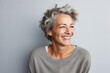 © Leon Waltz - portrait of a happy Israeli woman in her 50s wearing a cozy sweater against an abstract background