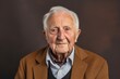 © Leon Waltz - portrait of a 100-year-old elderly Polish man wearing a chic cardigan against an abstract background