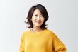 © Anne-Marie Albrecht - medium shot portrait of a Japanese woman in her 40s wearing a cozy sweater against a white background
