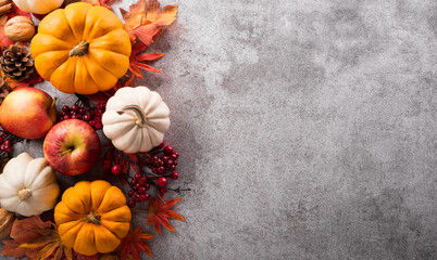 Wall Mural - thanksgiving and autumn decoration concept made from autumn leaves and pumpkin on stone background. 