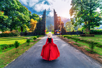 Woman walking at big entrance gate, Bali in Indonesia.