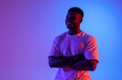 © Богдан Маліцький - african american man with crossed arms smiling in neon lighting, portrait of young guy in red blue lights
