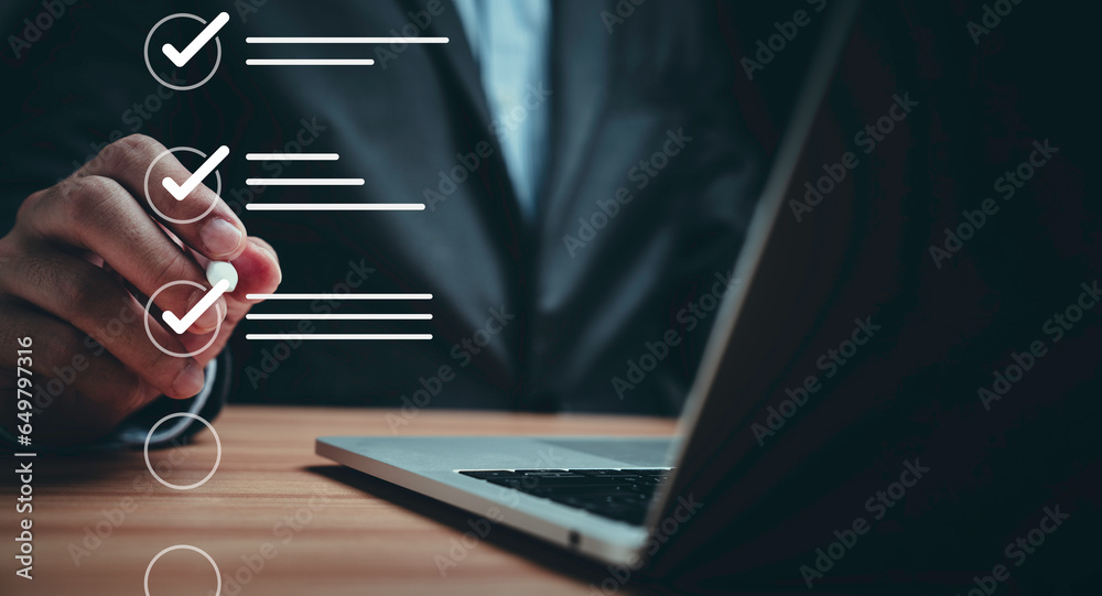 Businessman using laptop computer and touching to online electronic paper for approve ISO quality document control certification and project approval concept.