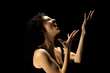 © vladimirfloyd - Tears of Despair: Woman's Silhouette with Raised Hands on Dark Background