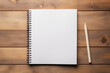© vejaa - Top view of open spiral blank paper notebook with pencil on wooden table desk background. Top view