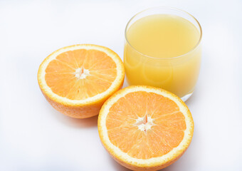 Wall Mural - Orange juice in a glass glass and the fruit of oranges. Refreshing drink on a white background of fruit.