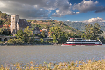 Wall Mural - Panorama of Wachau valley (Unesco world heritage site) with ship on Danube river against Sankt Michael church in Lower Austria, Austria