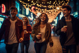 Fototapeta  - Four smiling friends cheering with hot drinks on a New Years night, enjoying and laughing togetherness on the street.