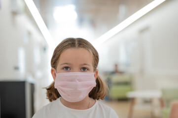 portrait of a child in a medical mask in a clinic at a doctor's appointment