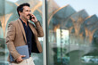 © Prostock-studio - Handsome middle aged man entrepreneur with laptop have phone conversation