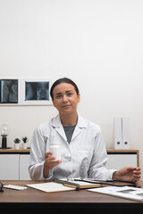 Poster - pharmacist While consulting with a patient online, a female doctor showcases a bottle of pills or vitamins on , discussing treatment options and issuing prescriptions. 