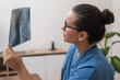 doctor thoroughly studies a radiology X-ray film, offering healthcare services and patient diagnosis in the hospital.