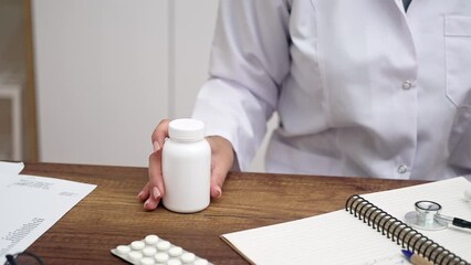 Poster - pharmacist consulting with patient, female doctor holding bottle of pills or vitamins, discussing treatment options and prescriptions