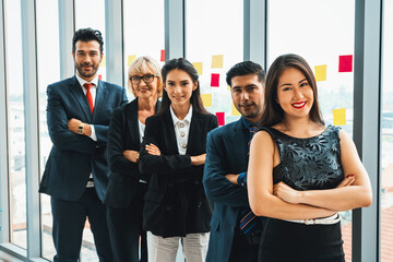 Wall Mural - Successful business people standing together showing strong relationship of worker community. A team of businessman and businesswoman expressing a strong group teamwork at the modern office. Jivy