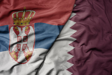 Canvas Print - big waving national colorful flag of serbia and national flag of qatar .