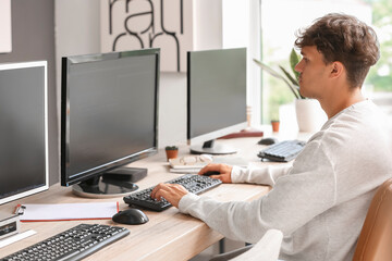 Sticker - Male programmer working with computer at table in office