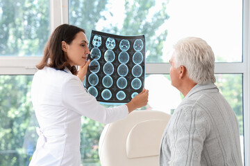 Wall Mural - Female doctor showing x-ray scan to senior patient in medical office