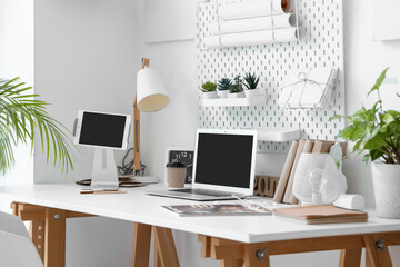 Sticker - Modern workplace with devices, pegboard and houseplants in light office