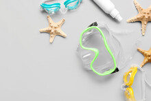 Composition With Snorkeling Mask, Googles, Cosmetic Product And Starfishes On Grey Background