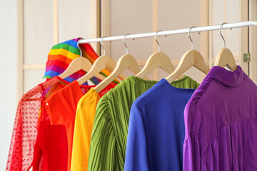 Rack with colorful clothes in bedroom, closeup