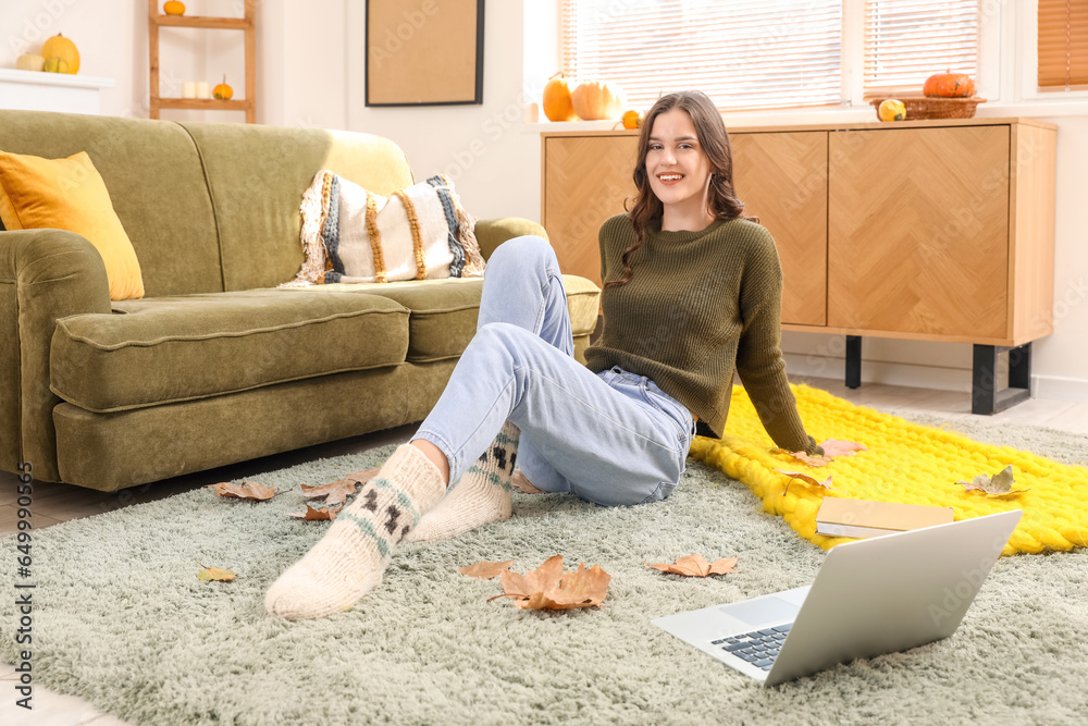Young woman sitting at home on autumn day