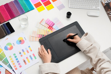 Poster - Female interior designer working with graphic tablet at table in office, top view