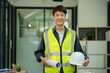 © Songsak C - Portrait of an Asian male engineer standing near a desk in the office.