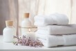 cosmetology and hygiene toiletries and accessories: fluffy towels with herbal bags and beauty treatment items, setting in spa massage center in white room