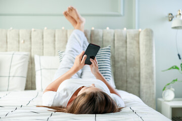 Wall Mural - Young woman lying on the bed