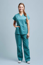 Full Length Portrait Of Smiling Female Doctor In Blue Scrubs Looking At Camera