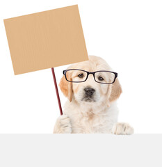 Poster - Funny smart Golden retriever puppy wearing eyeglasses shows empty placard above empty white banner. isolated on white background