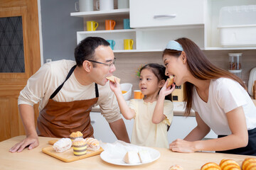 Wall Mural - Happy family with father, mother and daughter in kitchen eating sandwich for healthy together at home, happiness mom, dad and child with bonding and relation, lifestyles and nutrition concept.