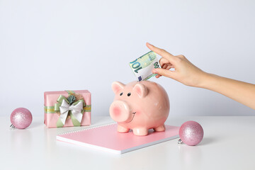 Wall Mural - Piggy bank, female hand with cash and gift box on white background