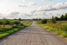 Panorama Of Fabulous Dirt Road With Avenue Of Trees In Beautiful Countryside With Blue Sky, Clouds On Sunny Summer Day