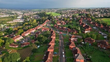 Wall Mural - UK urban scene: Aerial footage of Yorkshire's red brick council housing estate in the morning sun, with people strolling through the streets.