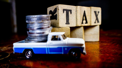 tax writing on wood with coins on it and a toy car in the foreground