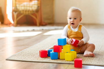 Wall Mural - Adorable Infant Baby Playing With Stacking Building Blocks At Home