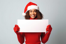 Woman In Red Santa Suit With Santa Hat Holding White Blank Card. Christmas Banner, Advertising Background, Copy Space.