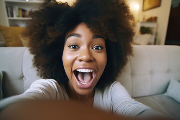 Young African American woman taking a selfie photo at home to post on social media