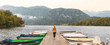 © M.studio - Woman tourist walking on pier with boats on Bohinj lake in Slovenia- travel,vacation,tour tourism