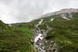 Green mountain slope on cloudy day. Landscape on trekking trail to Vihren peak. Pirin National Park in Bulgaria.